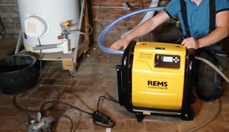Chauffagiste utilise une machine de désembouage